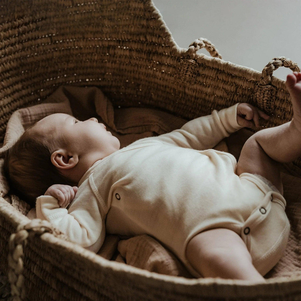 Bébé dans un berceau  portant un body en laine mérinos naturelle non traitée, doux pour la peau et adapté à la régulation thermique Couleur : Naturel