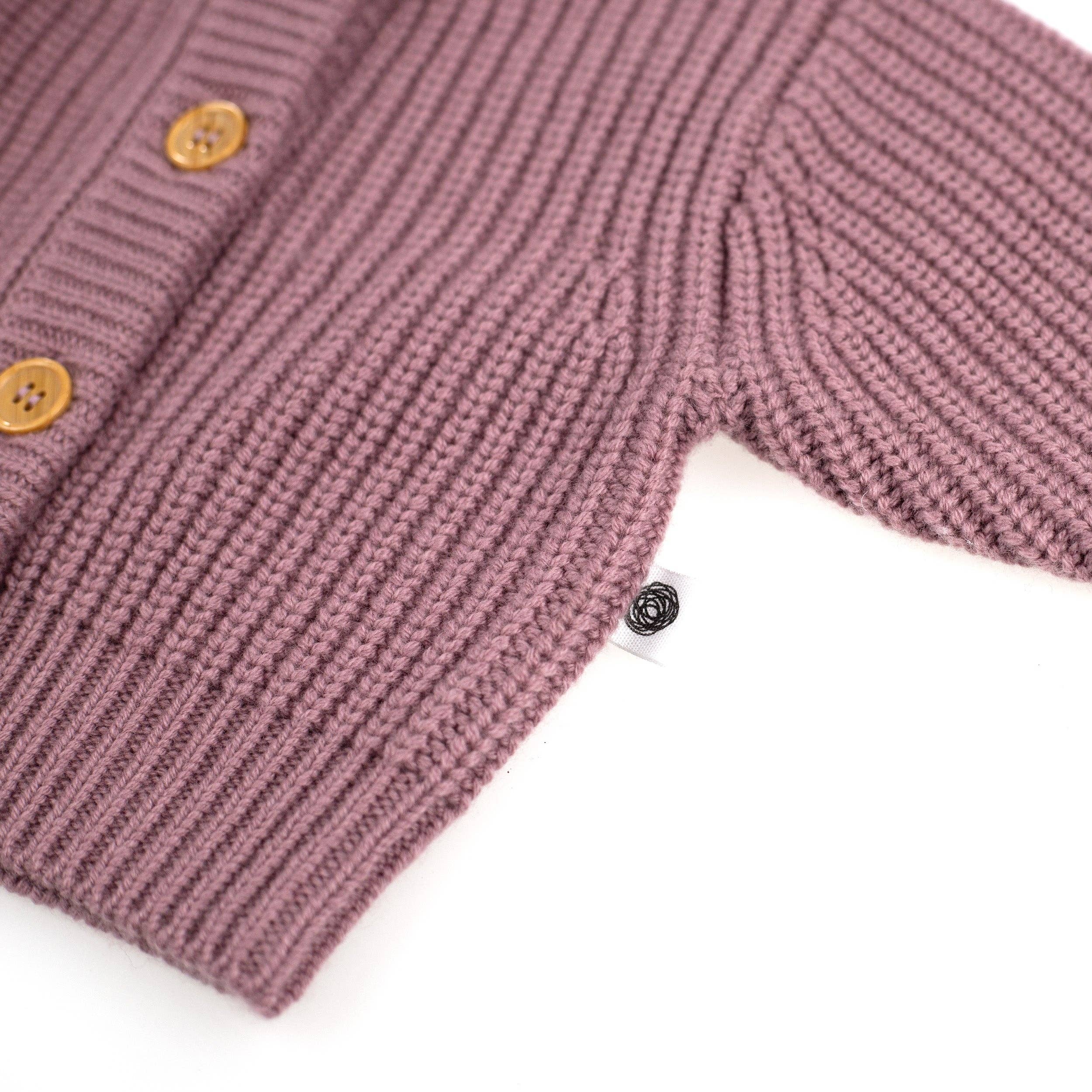 Détail du tricot en laine mérinos non traitée d’un gilet bébé, maille naturelle et isolante Couleur : Haze, zoom sur l'étiquette