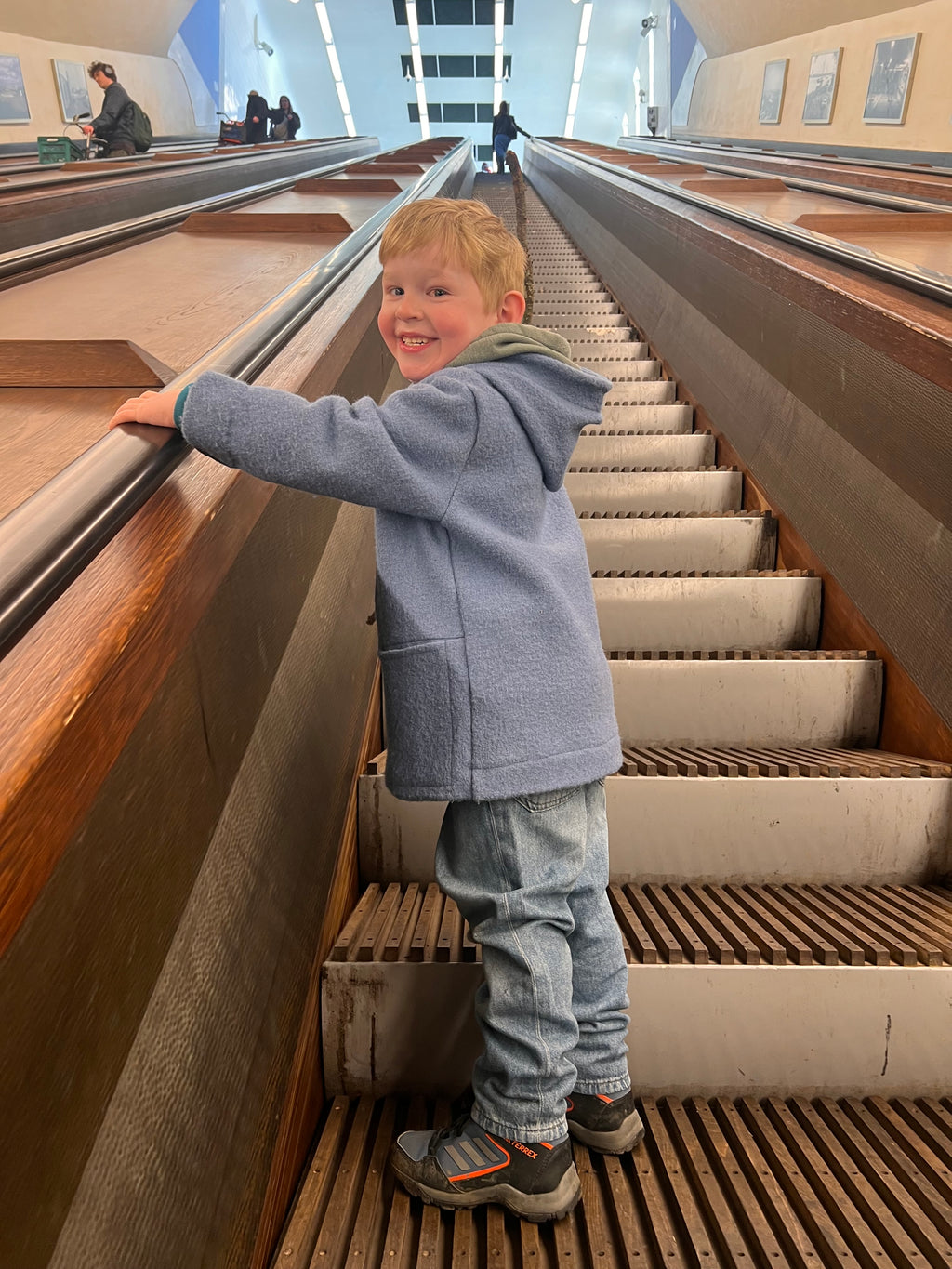 Vue de coté d'un manteau pour enfant bleuJ'M tout doux en laine chaude, avec option fermeture éclair (zip) pour une protection optimale.