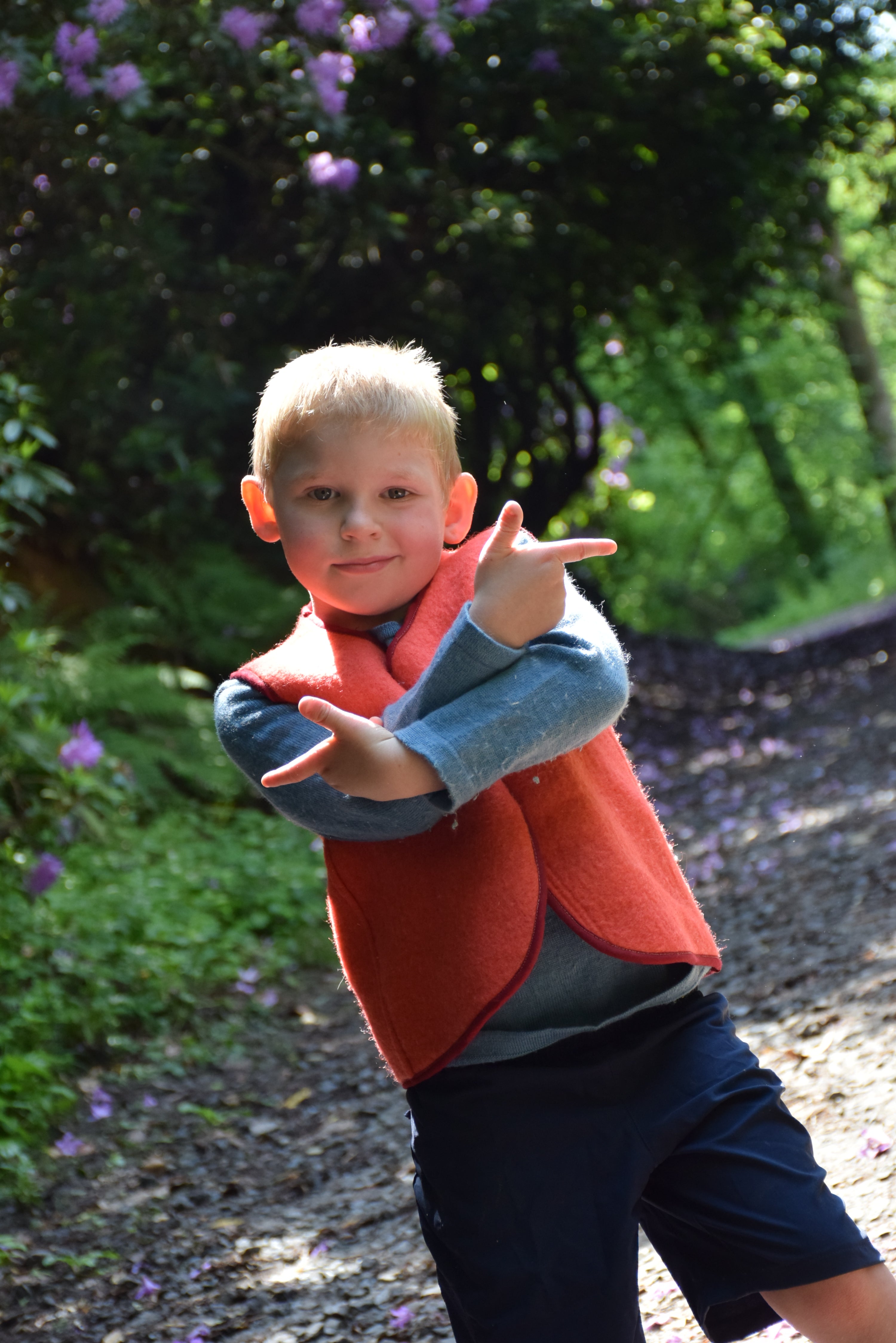 Enfant portant un  gilet sans manches en laine upcyclée de couleur rouge. vue de face