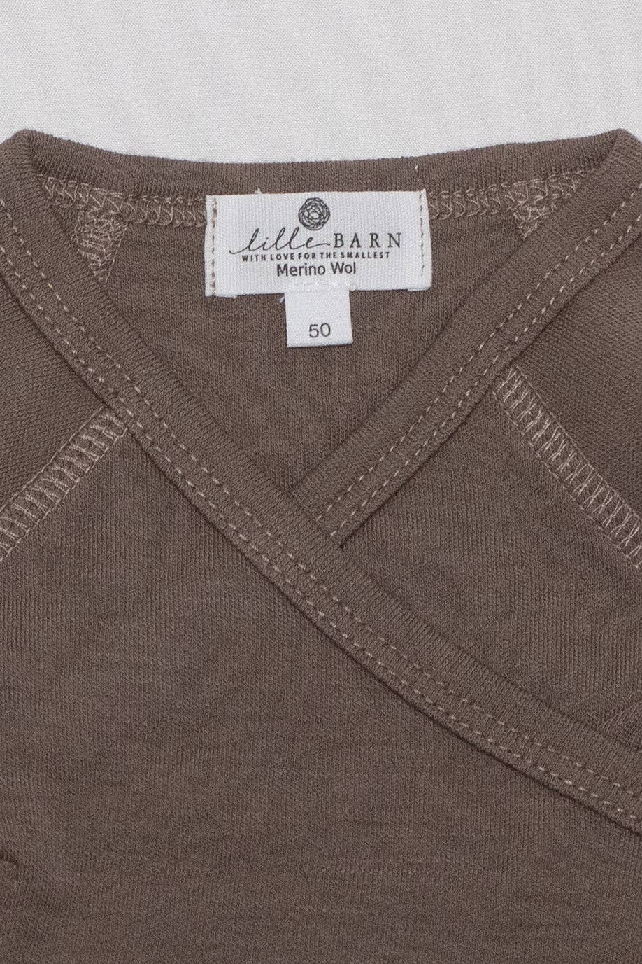 Gros plan sur la maille fine d’un body bébé en laine mérinos non traitée, fibre respirante et naturelle Couleur : Noix