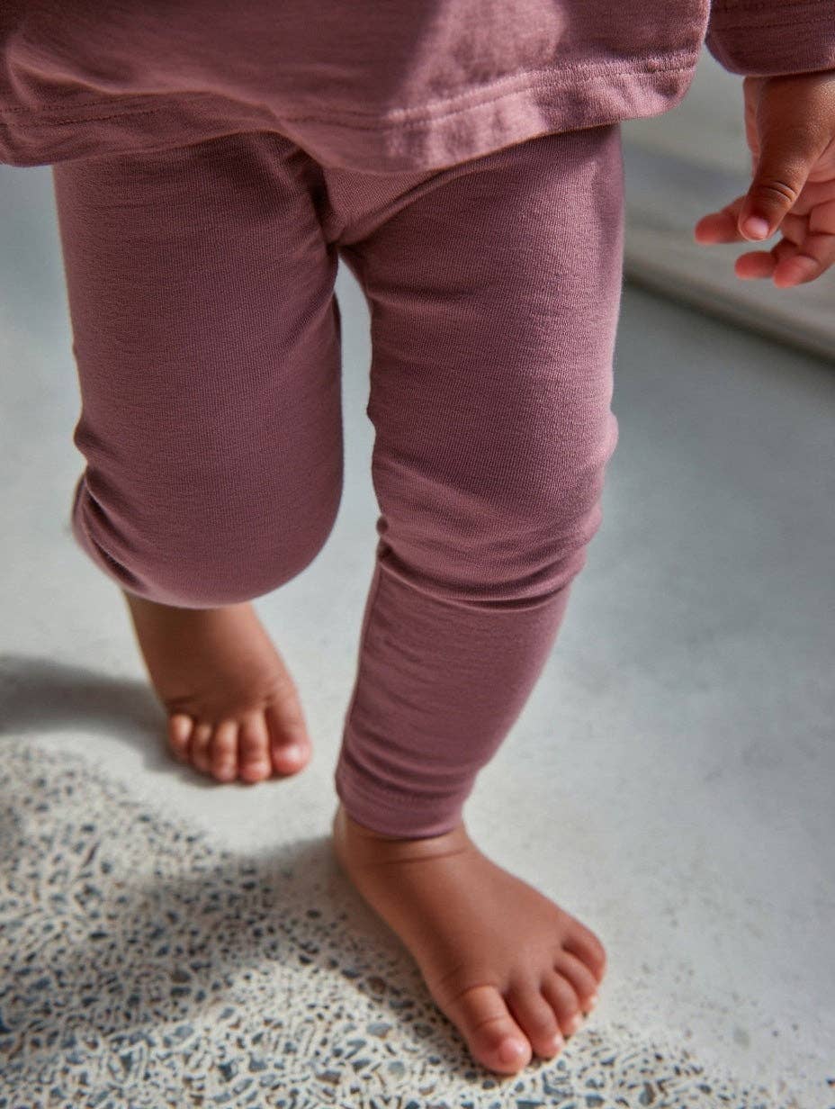 Bébé habillé d’un legging en laine mérinos naturelle non traitée, confortable et thermorégulant Couleur : Grape Shake