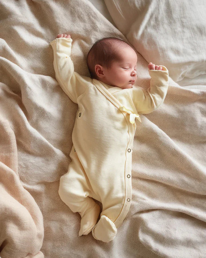 Bébé portant une combinaison en laine mérinos non traitée, idéale pour protéger du froid tout en laissant respirer la peau Couleur : Naturel